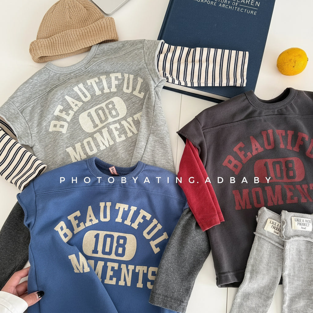 Collection of clothing items including shirts and pants with 'BEAUTIFUL 108 MOMENTS' text on a white surface.